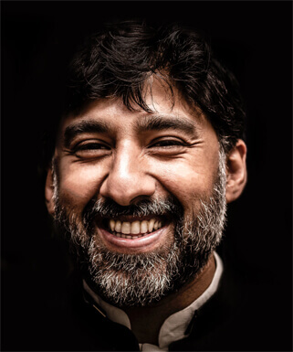 A man with a beard smiling.